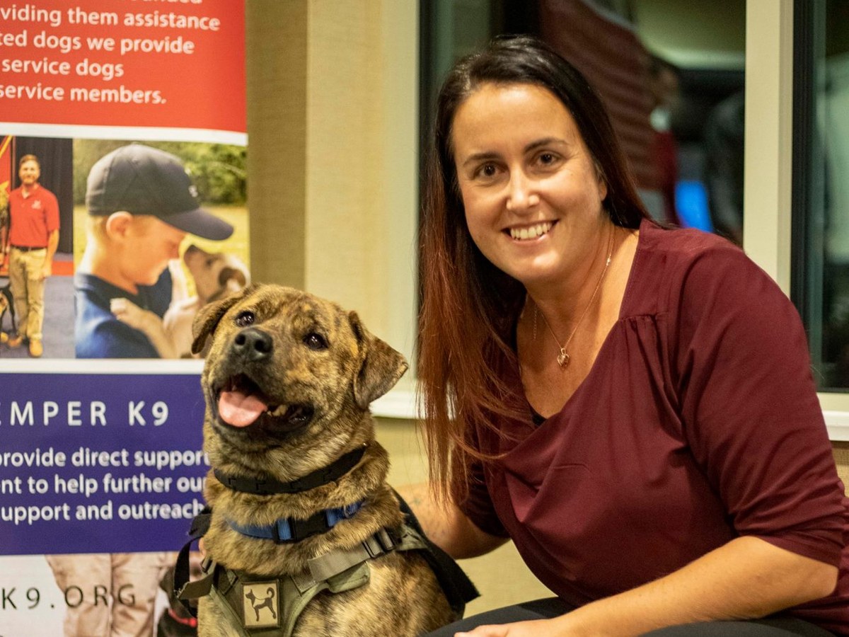 Semper K9 supporter with a service dog in training